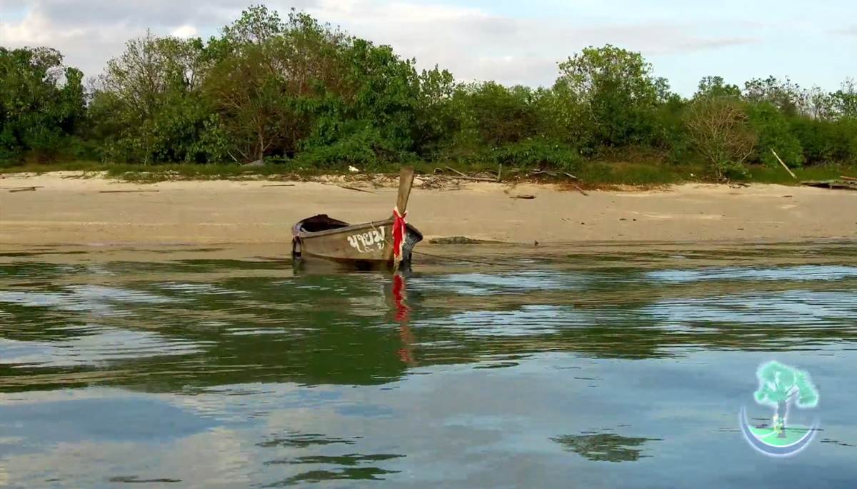 Picture shows empty beach on Coconut Island Phuket with long tail boat in front